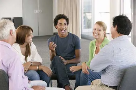 Five people sitting in a circle in a group counseling session, one of them speaking