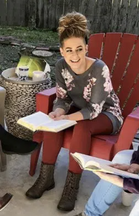 Woman smiling and reading during a 12-step group session focused on addiction recovery and spirituality