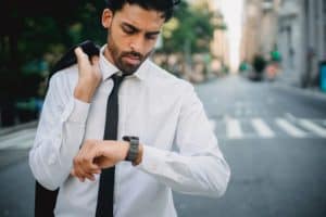 High-functioning alcoholic checking his watch to see if it's time for a drink.
