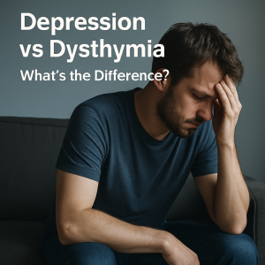 A man sitting on a couch with his head in his hands, visually representing the emotional struggle of depression vs dysthymia.