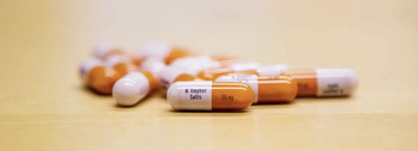 Prescription opioid capsules on a table representing the risk of misuse and addiction.