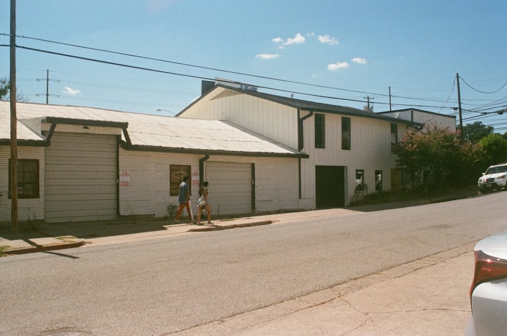 a couple of people walking down a street next to a building -- Photo by Gabriel Martinez on Unsplash