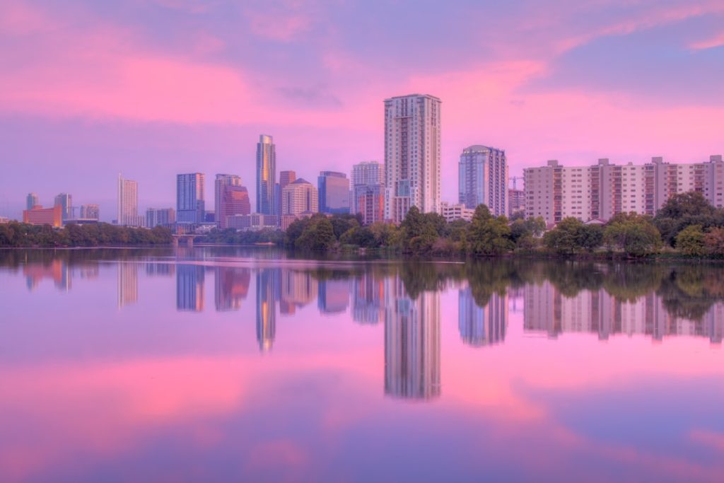 a city skyline with a body of water in front of it -- Photo by Cody McLain on Unsplash