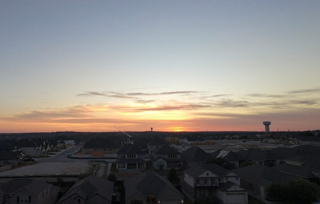Sunset over a suburban neighborhood with distant hills. -- Photo by Jeff Le on Unsplash