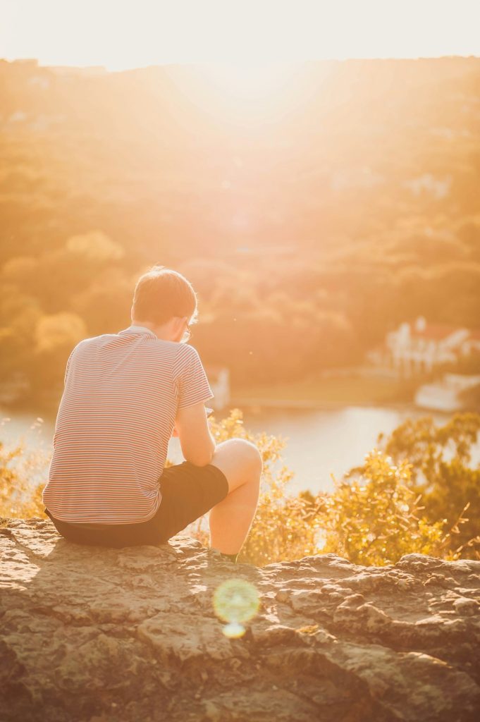 man sitting on rock -- Photo by James Balensiefen on Unsplash