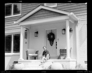 Person sitting on front porch steps of a house. -- Photo by Brooke Balentine on Unsplash