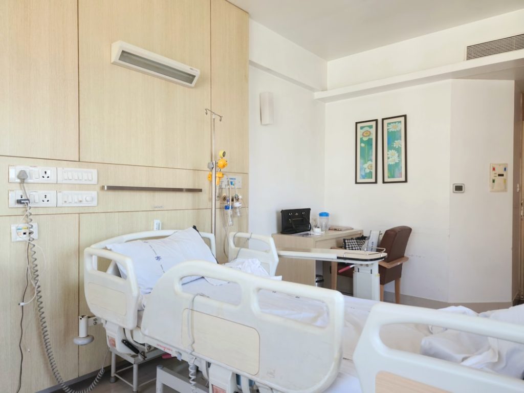a hospital room with a bed and a desk -- Photo by Zoshua Colah on Unsplash