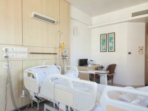 a hospital room with a bed and a desk -- Photo by Zoshua Colah on Unsplash