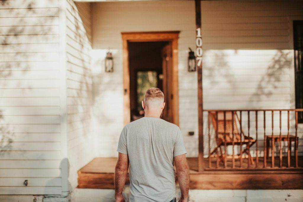 A man standing in front of a house -- Photo by Samuel Yongbo Kwon on Unsplash