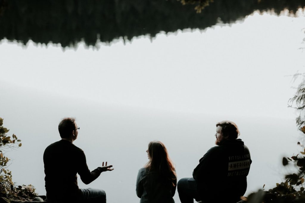 silhouette of three people sitting on cliff under foggy weather -- Photo by Priscilla Du Preez 🇨🇦 on Unsplash