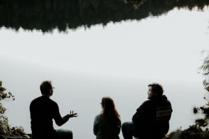 silhouette of three people sitting on cliff under foggy weather -- Photo by Priscilla Du Preez 🇨🇦 on Unsplash