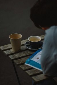 a person sitting at a table with a couple of cups of tea -- Photo by Eugene Chystiakov on Unsplash